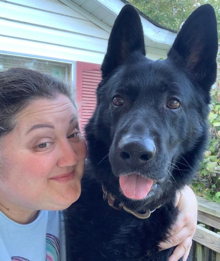 A vet embraces a black dog